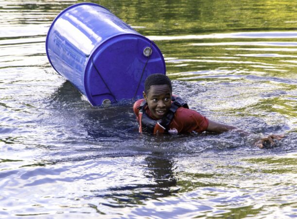 A cadet swimming in water due to the makeshift raft breaking